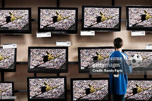 boy watching soccer in a television store - sportbegriff stock-fotos und bilder
