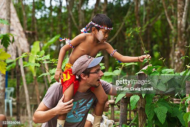 a western volunteer gives a ride to a thai boy in the organic garden at the home and life orphanage in phangnga - khao lok, thailand - khao lak stock pictures, royalty-free photos & images