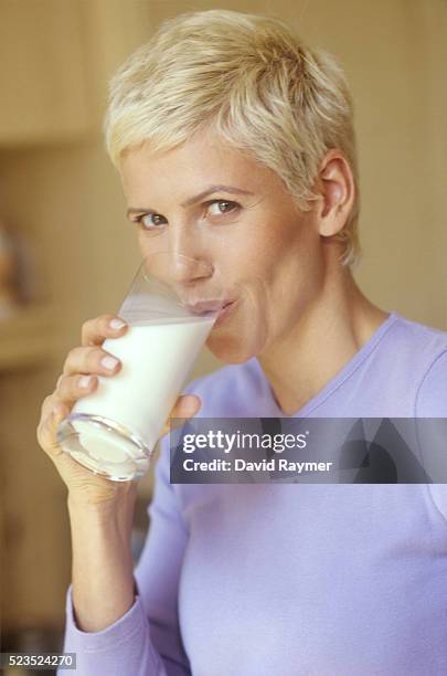 portrait of woman drinking glass of milk - david swallow stock pictures, royalty-free photos & images
