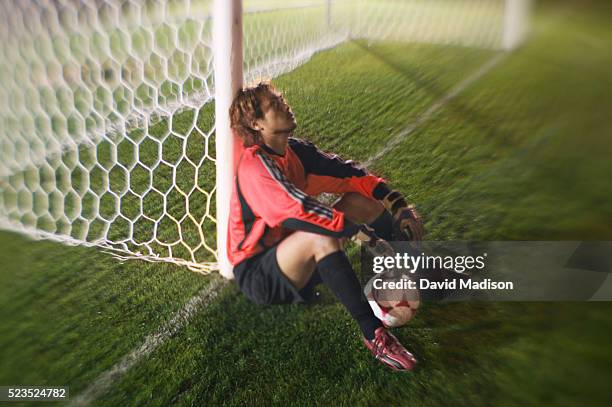 dejected goalie sitting at goal - bad goalkeeper stock pictures, royalty-free photos & images