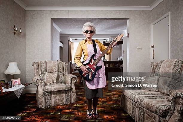 senior woman playing electric guitar - groovy fotografías e imágenes de stock