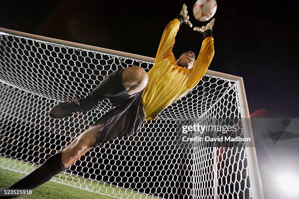 goalie blocking soccer ball - of the best football kits stock-fotos und bilder