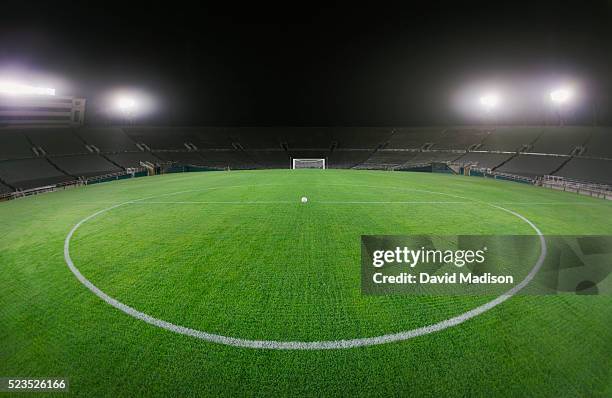 soccer ball in empty stadium - soccer field stock-fotos und bilder