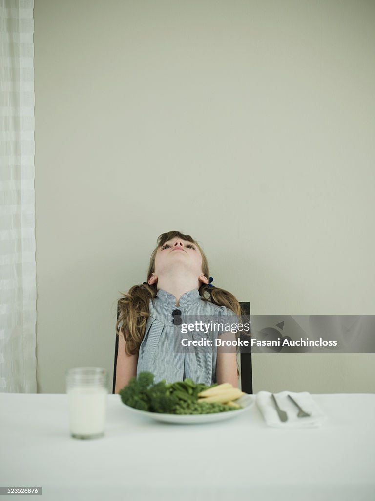 Young girl not wanting to eat vegetables