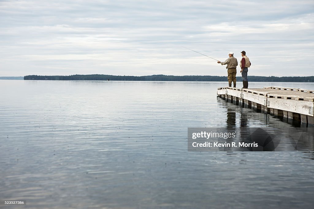 Fishermen fly-fishing off dock on Sebago Lake, Maine