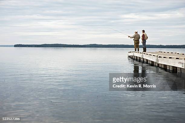 fishermen fly-fishing off dock on sebago lake, maine - pier stock pictures, royalty-free photos & images