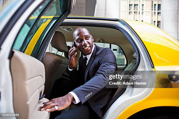 businessman talking on cell phone in back seat of taxi - businessman taxi stock-fotos und bilder