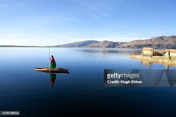 woman wearing traditional costume, using traditionally made reed boat. the uros islands, lake titicaca. puno. peru. - hugh sitton india fotografías e imágenes de stock