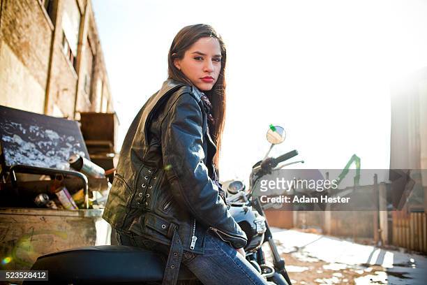 attractive mid adult woman posing on motorbike - leather jacket stockfoto's en -beelden
