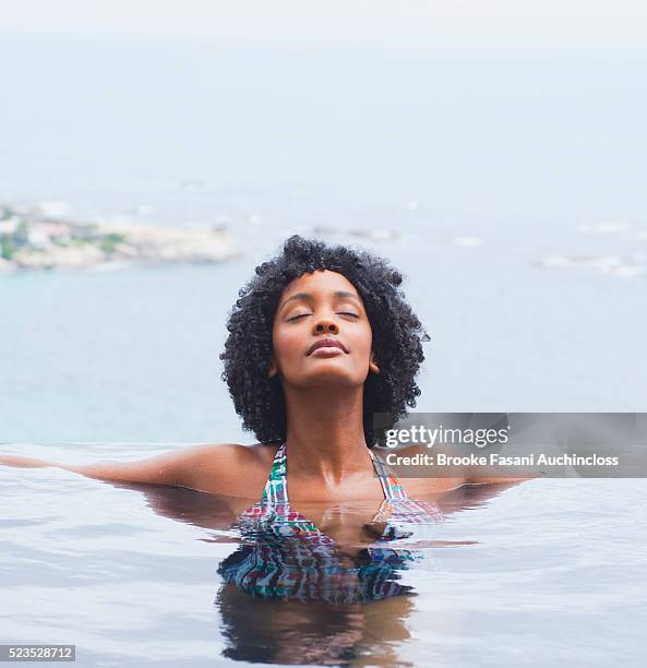 young woman relaxing in swimming pool - woman pool relax fotografías e imágenes de stock