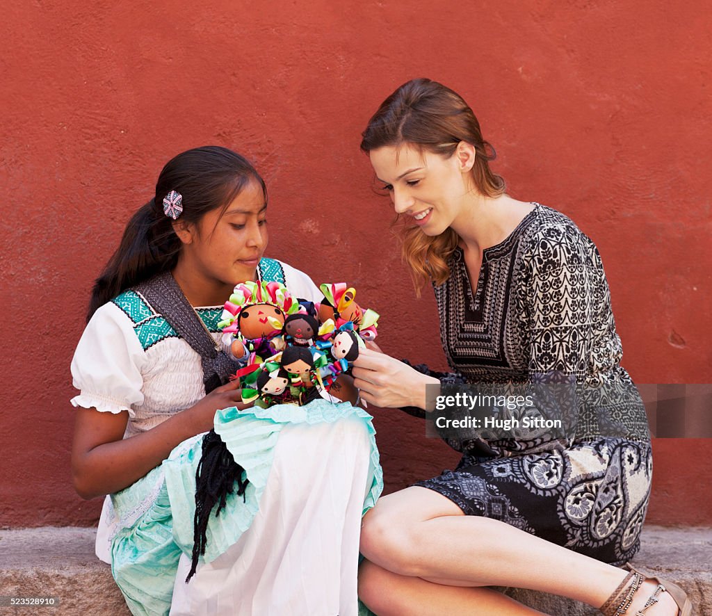 Tourist buying Mexican dolls from saleswoman