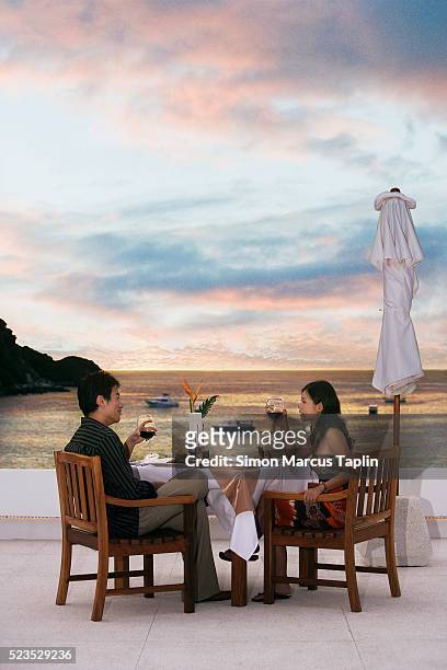 couple dining by seaside - asian couple dining stockfoto's en -beelden