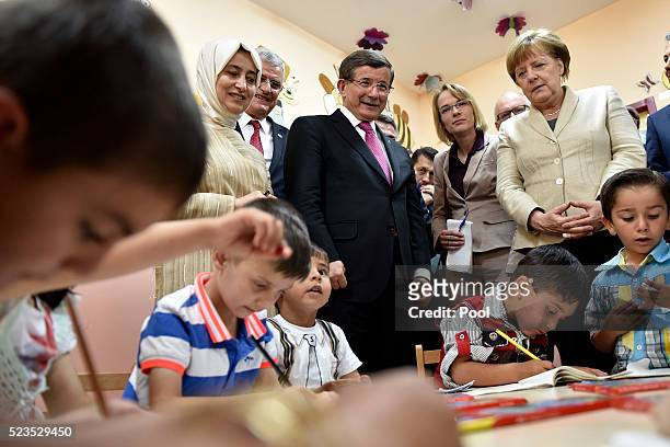 In this photo provided by the German Government Press Office , Turkey's Prime Minister, Ahmet Davutoglu looks on as German Chancellor Angela Merkel...