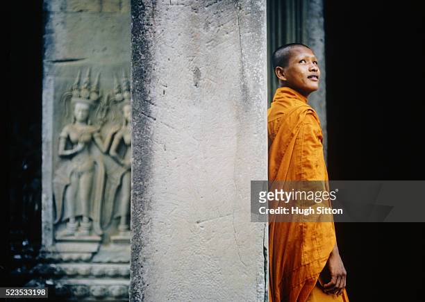 buddhist monk against column - hugh sitton stock pictures, royalty-free photos & images