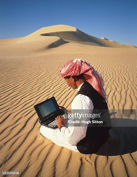 bedouin man using laptop computer, sahara desert, egypt, africa - laptop desert stock pictures, royalty-free photos & images