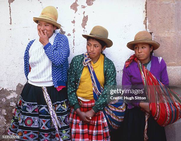three young peruvian woman leaning on a wall, peru, cusco - hugh sitton stock-fotos und bilder