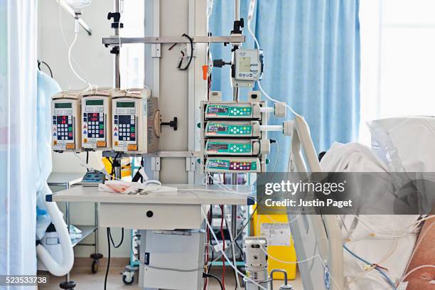 patient in intensive care bed in uk hospital - unidade de tratamento intensivo - fotografias e filmes do acervo