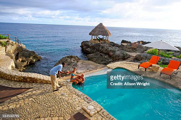 montego bay, jamaica. couple having drinks at the pool - montego bay stock-fotos und bilder