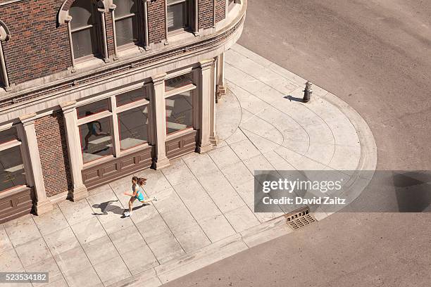 woman running on the sidewalk - marciapiede foto e immagini stock