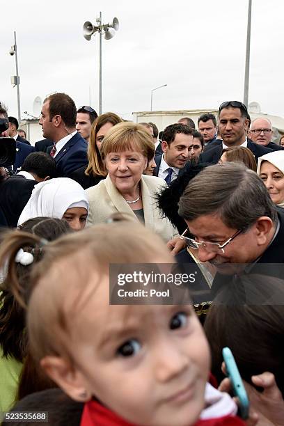 In this photo provided by the German Government Press Office , Turkey's Prime Minister, Ahmet Davutoglu and German Chancellor Angela Merkel greet...