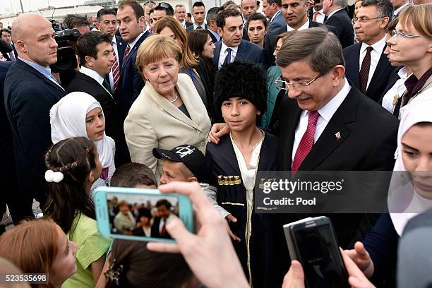 In this photo provided by the German Government Press Office , Turkey's Prime Minister, Ahmet Davutoglu and German Chancellor Angela Merkel greet...