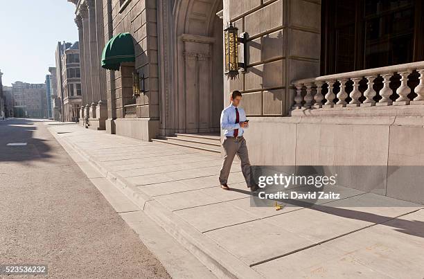 man texting and walking near a banana peel - injured street stockfoto's en -beelden