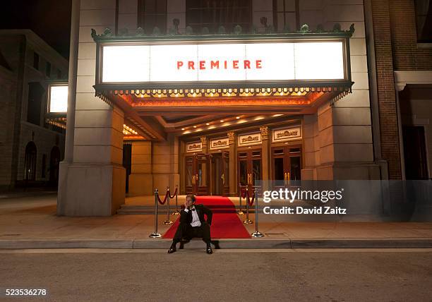 man sitting on the curb of the red carpet - movie in tuxedo stock pictures, royalty-free photos & images