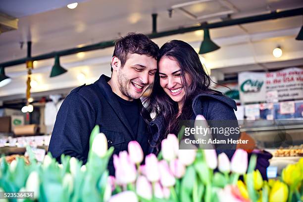 couple buying flowers at market - pike place market sign stockfoto's en -beelden