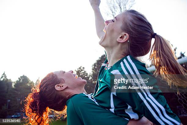 two female friends cheering - sportbegriff stock-fotos und bilder