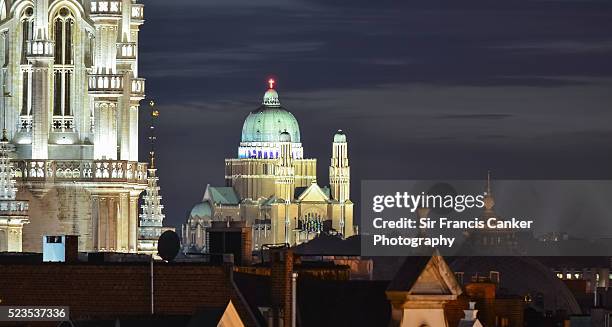 brussels skyline with koekelberg basilica and majestic town hall gothic tower illuminated at dusk - brussels skyline stock pictures, royalty-free photos & images