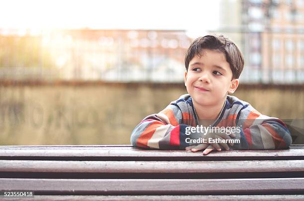 thoughtful boy sitting on a bench - innocence project stock pictures, royalty-free photos & images