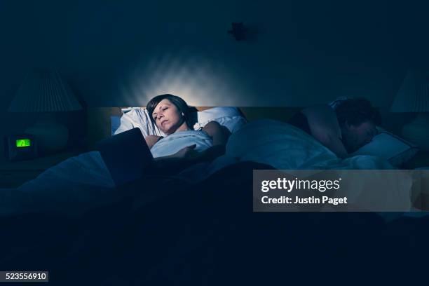 woman using tablet in bed - sleepless stock pictures, royalty-free photos & images