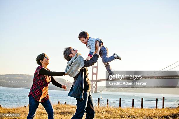 two moms playing with son (2-3) in front of golden gate bridge, san francisco, california, usa - young gay boys fotos stockfoto's en -beelden