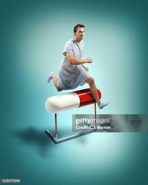 man jumping over large pill, digitally manipulated image - 徹底 ストックフォトと画像