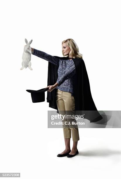 studio shot of female magician with hat and rabbit - magician stockfoto's en -beelden
