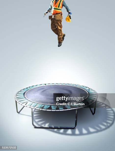 construction worker jumping on trampoline - trampoline stock-fotos und bilder