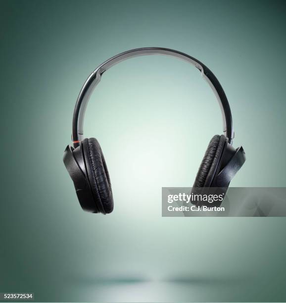 studio shot of headphones, turquoise background - headphones bildbanksfoton och bilder