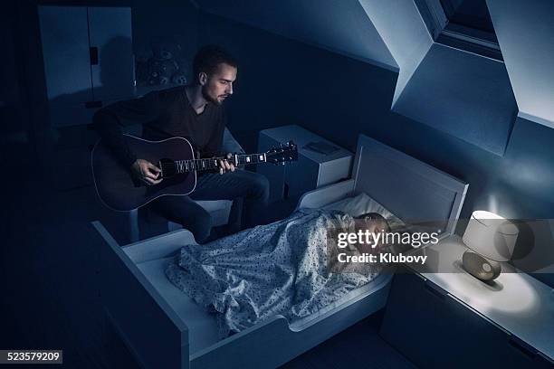 father playing lullabies to his daughter - zingende man stockfoto's en -beelden