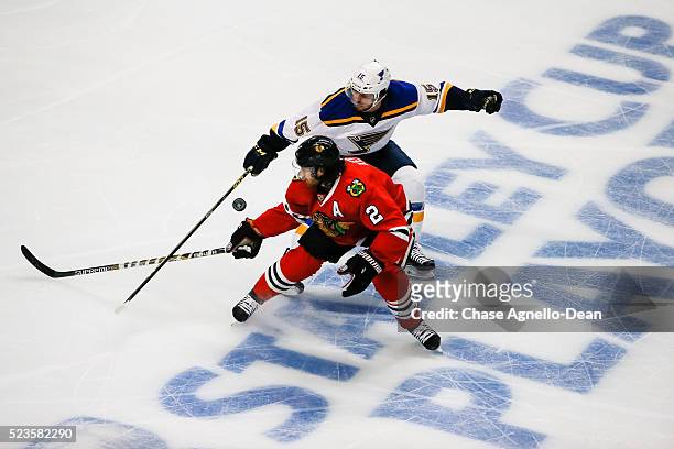 Robby Fabbri of the St. Louis Blues and Duncan Keith of the Chicago Blackhawks swing at the puck in the first period of Game Six of the Western...