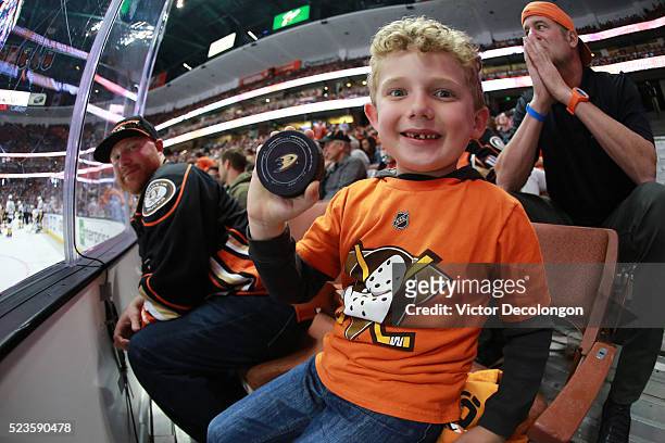 Young Anaheim Ducks hockey fan Reed holds up a puck given to him by an on-ice official during a break in play in the third period of Game Five of the...