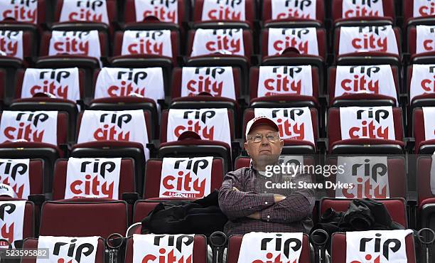 Fan sits in his seat surrounded by free t-shirts and hats laid out on the seats before Game Three of the Western Conference Quarterfinals during the...