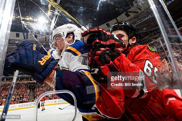 Scottie Upshall of the St. Louis Blues checks Andrew Shaw of the Chicago Blackhawks into the glass in the second period of Game Six of the Western...