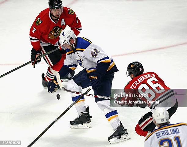 David Backes of the St. Louis Blues tries to control the puck between Brent Seabrook and Teuvo Teravainen of the Chicago Blackhawks in Game Six of...