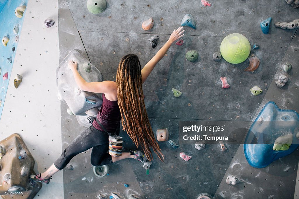 Indoor climbing in the bouldering gym wall.