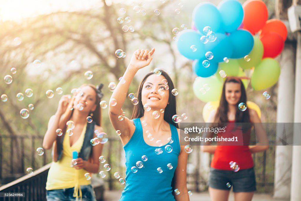 Group of friends having fun with soap bubbles