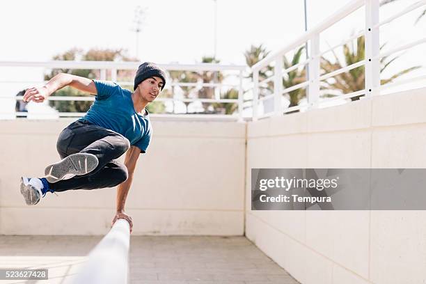 free running parkour athlete in the beach of barcelona - free running stock pictures, royalty-free photos & images