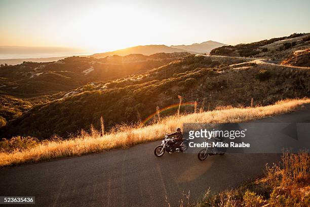 two friends riding motorcycles together on country roads, santa barbara county, california, usa - sunset road photos et images de collection
