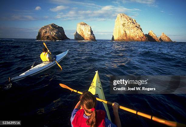 sea kayakers heading for sea stacks - colima fotografías e imágenes de stock