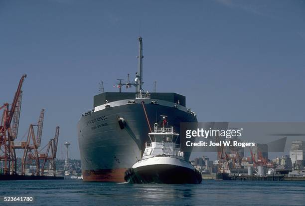tugboat pulling cargo ship - schlepper stock-fotos und bilder