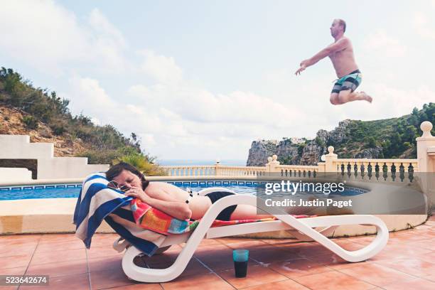 man about to splash sunbathing woman - women sunbathing pool stock pictures, royalty-free photos & images